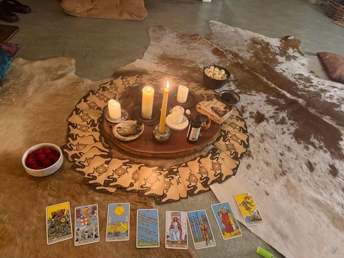A candlelit altar ringed with cards, ready for circle