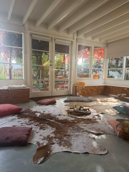 A sunlit circle space with cushions and cowhide rugs